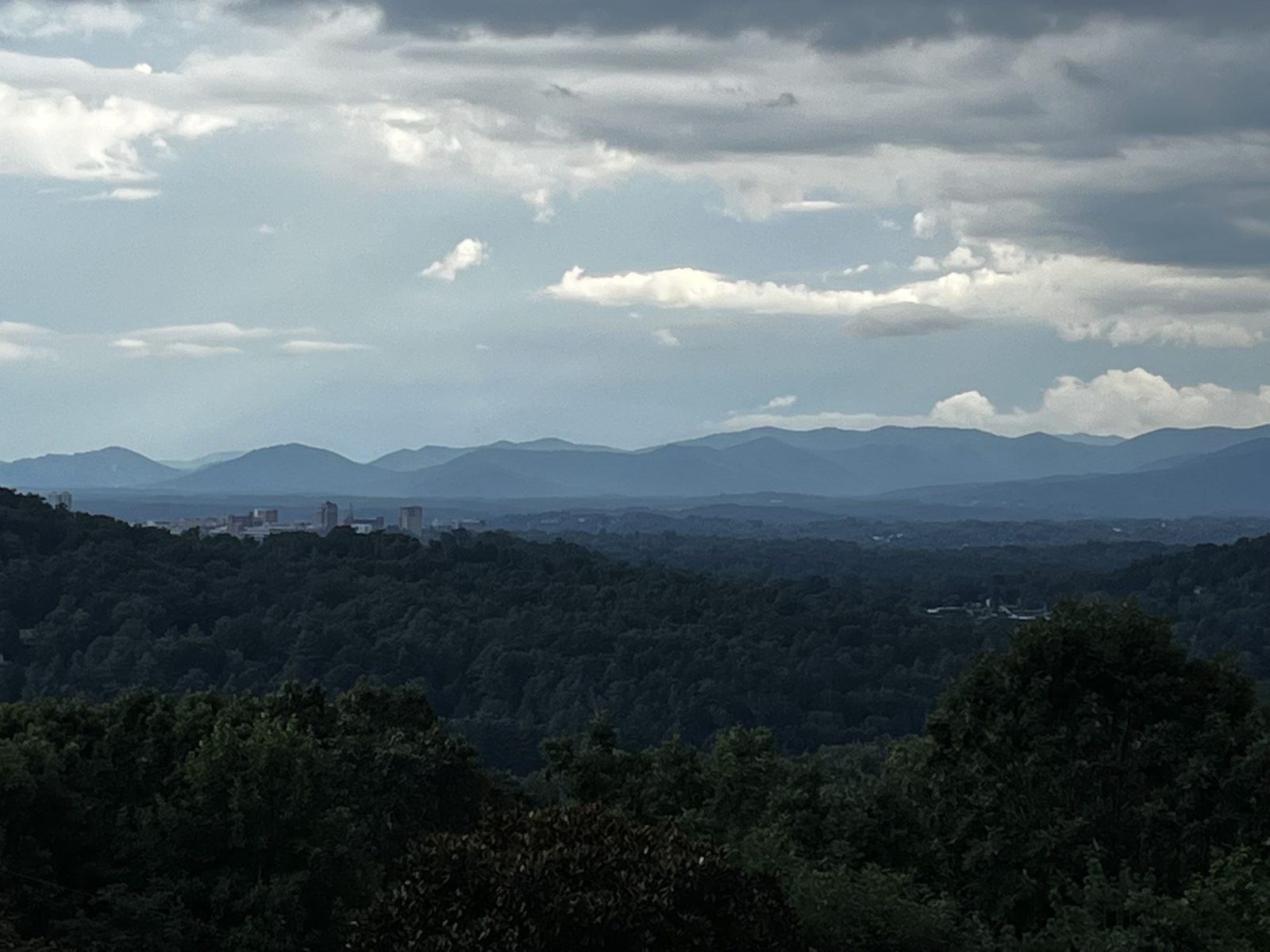 The Blue Ridge: layers of blue mountains fading into a stormy sky above dark green forest